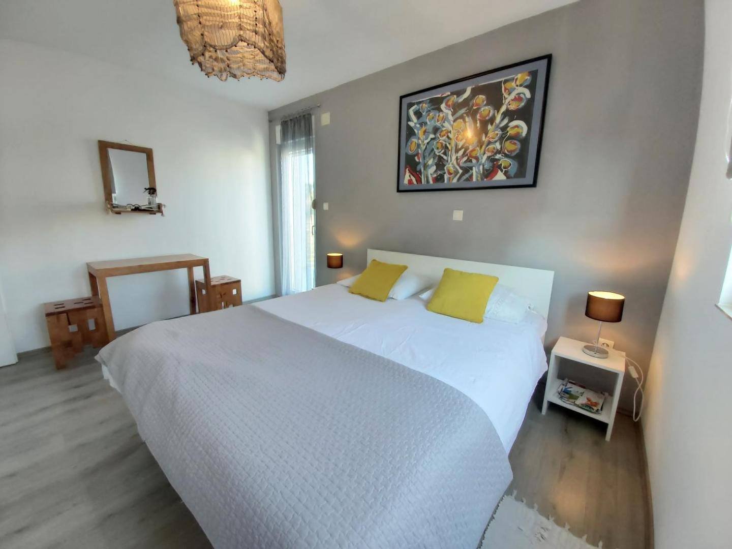Guest House Dragić: bedroom with a large white bed and yellow cushions