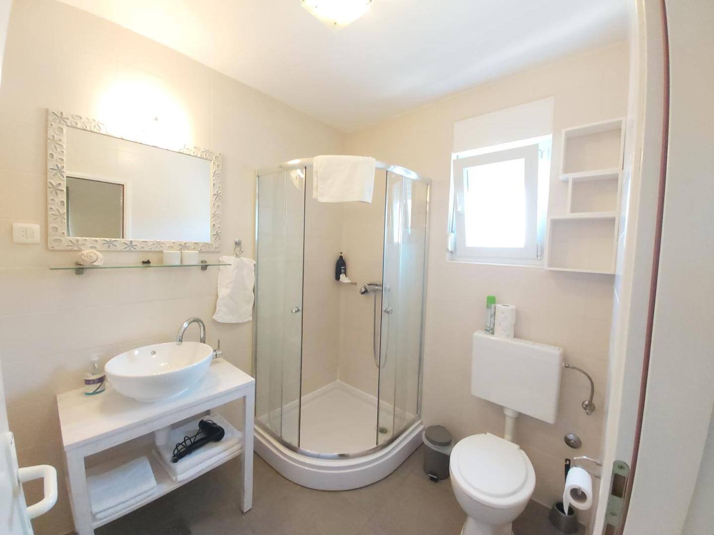 Guest House Dragić: bathroom with a shower and washbasin